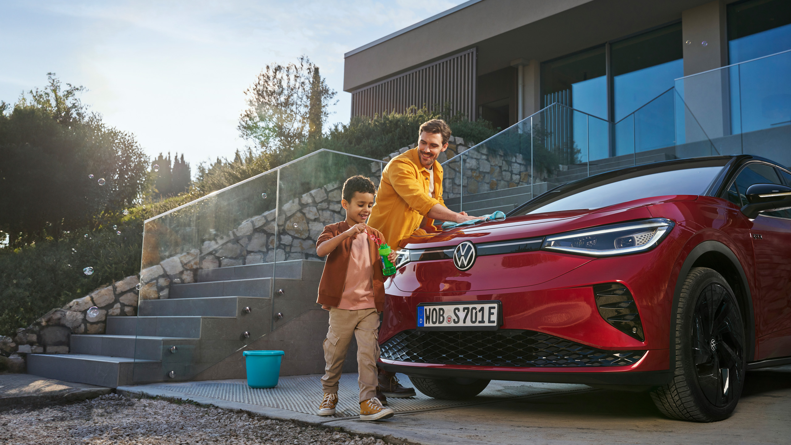 Father and son washing the windscreen of their VW with VW care products